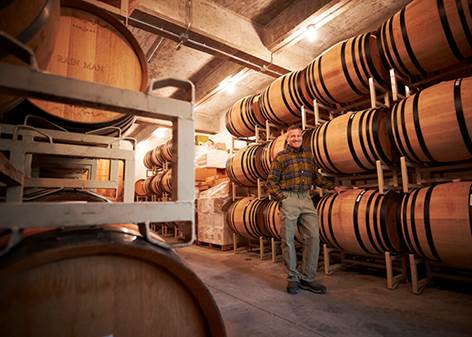A person standing in a room with barrels Description automatically generated
