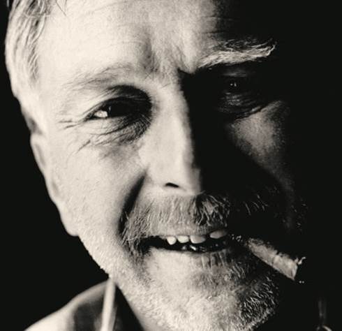 A person with a cigar in his mouth Description automatically generated